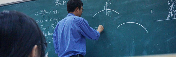 Professor writing on blackboard (c) unsplash
